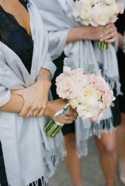 women hold flowers with shawls